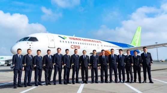 a group photo in front of the C919 aircraft
