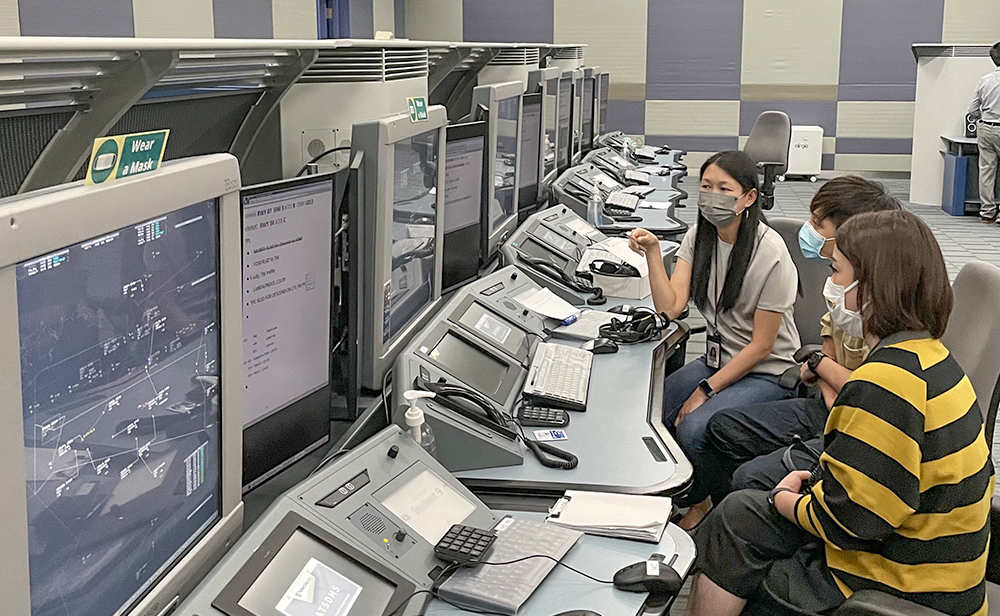 An air traffic control trainee (centre) was under assessment by his supervisor and on-the-job-training instructor.